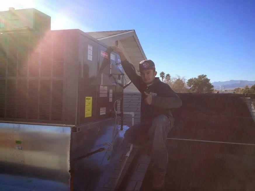 HVAC technician performing AC Tune-Up on a rooftop unit in Pullman