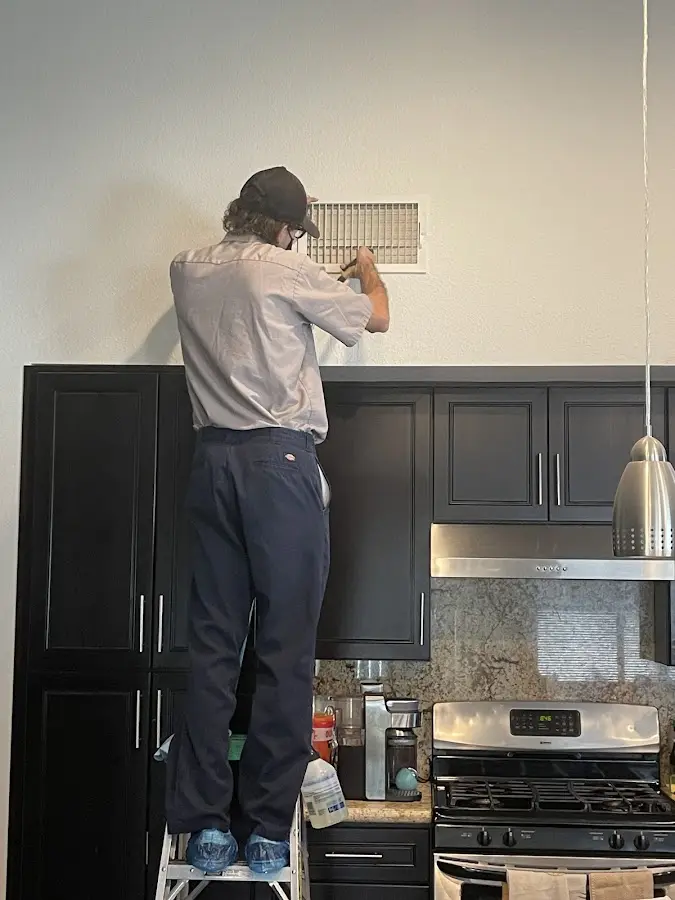Technician inspecting an air vent during HVAC service in Pullman